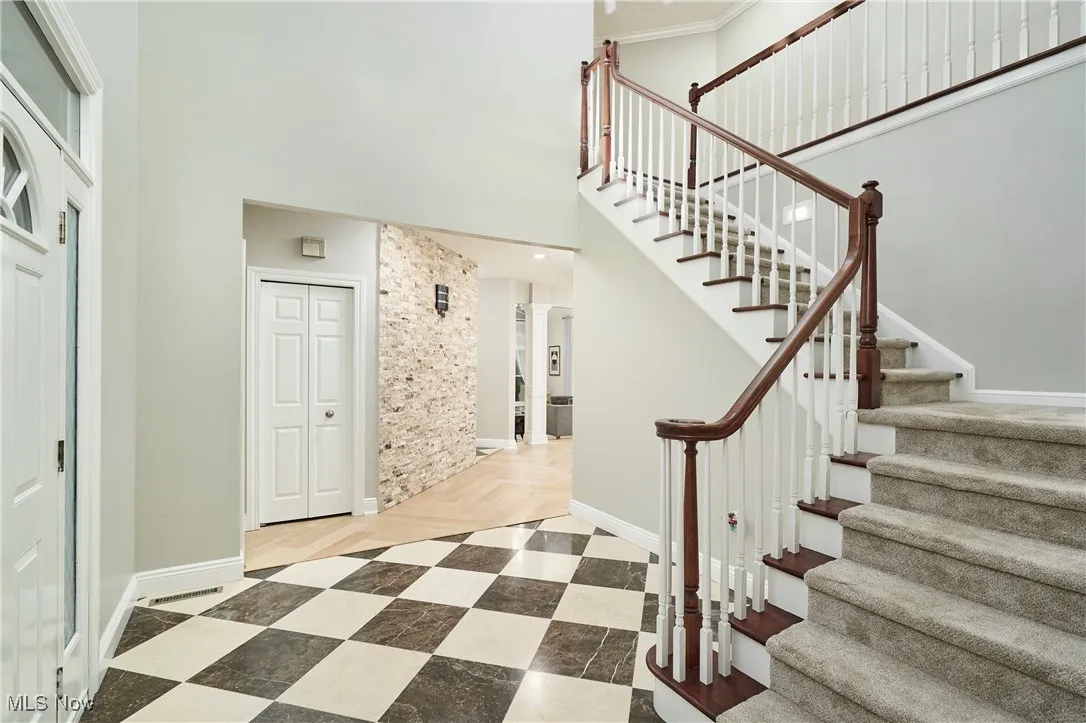 Staircase featuring a towering ceiling and baseboards
