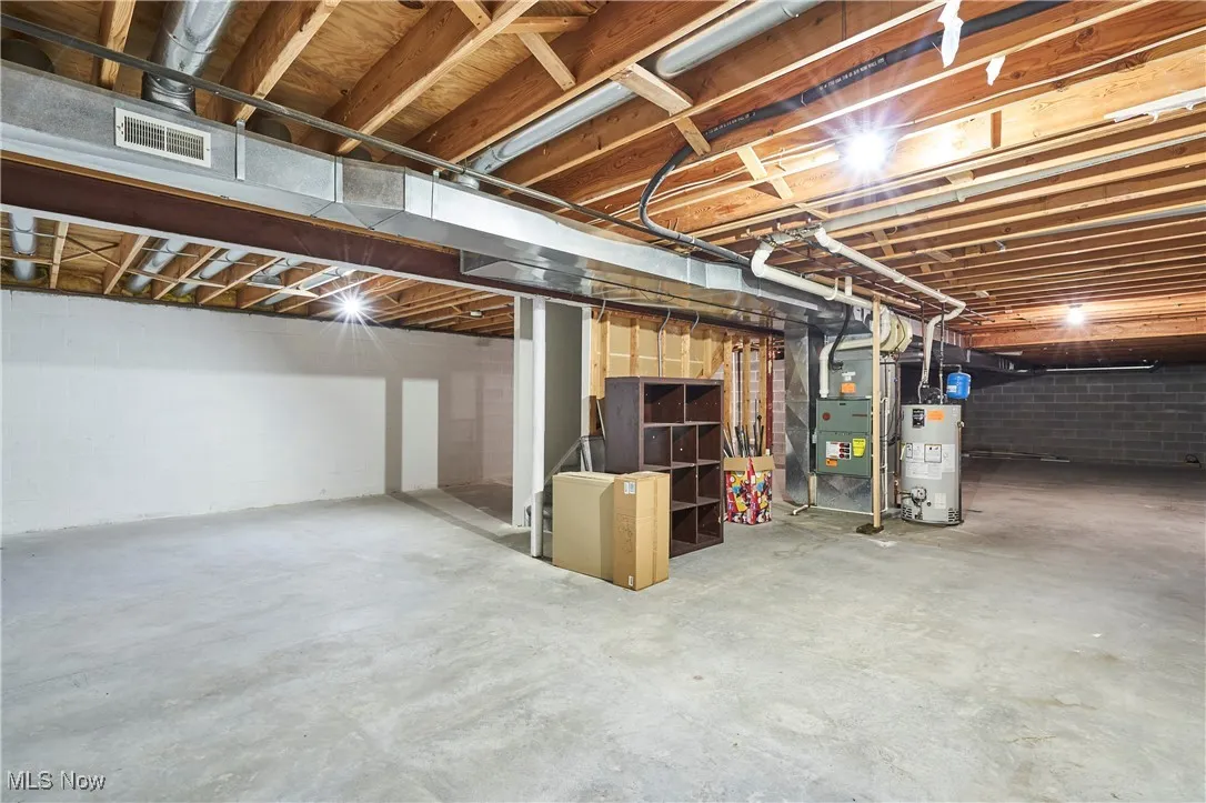 Unfinished below grade area with gas water heater and heating unit