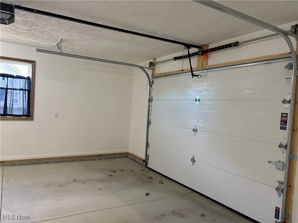 Garage with baseboards and a garage door opener