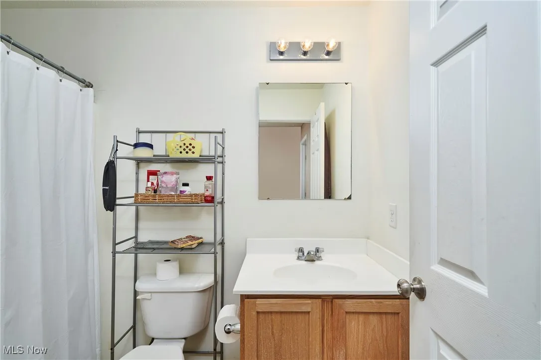 Full bath featuring curtained shower and vanity on upper level for kids or guests.