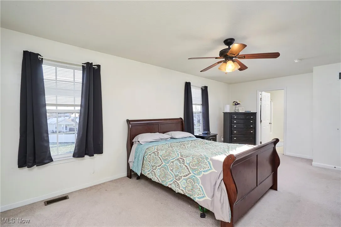 Large Primary Bedroom featuring carpet flooring and a ceiling fan, and natural lighting.