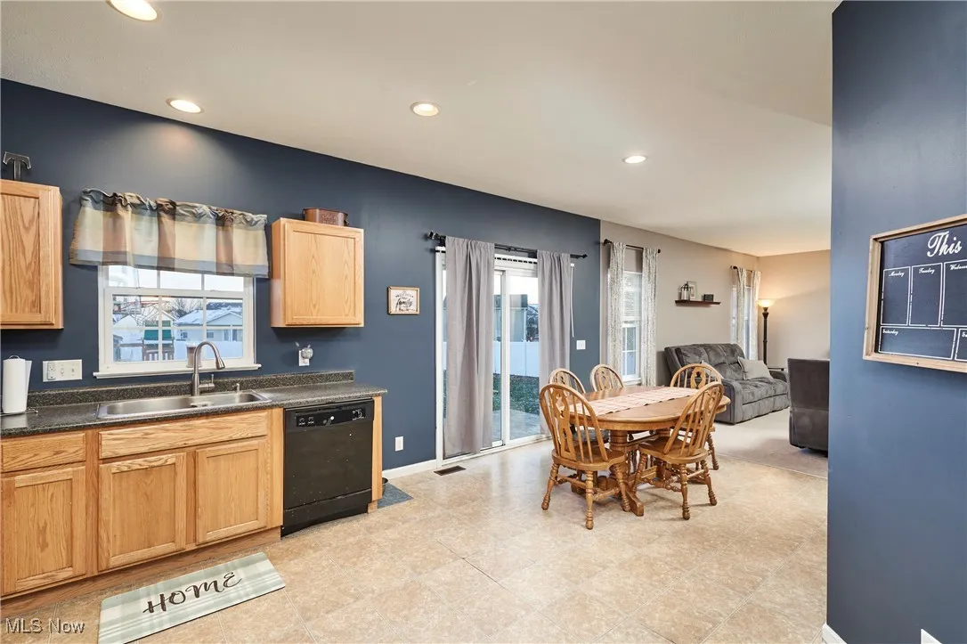 Kitchen featuring recessed lighting, dishwasher, dark countertops, and open floor plan