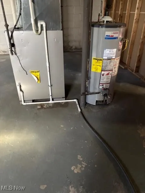 Utility room featuring heating unit and gas water heater