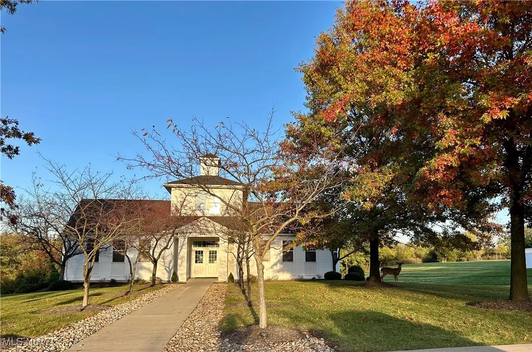 View of front of the club house with a front lawn and a chimney