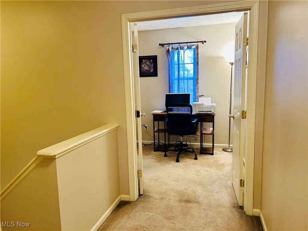 Home office featuring light carpet and baseboards