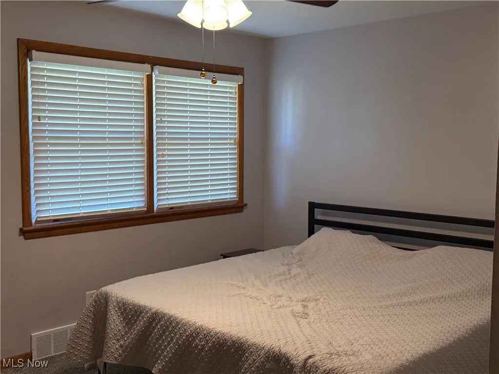 Bedroom featuring a ceiling fan and baseboards