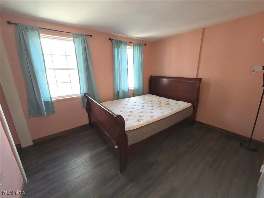 Bedroom featuring dark wood finished floors and baseboards