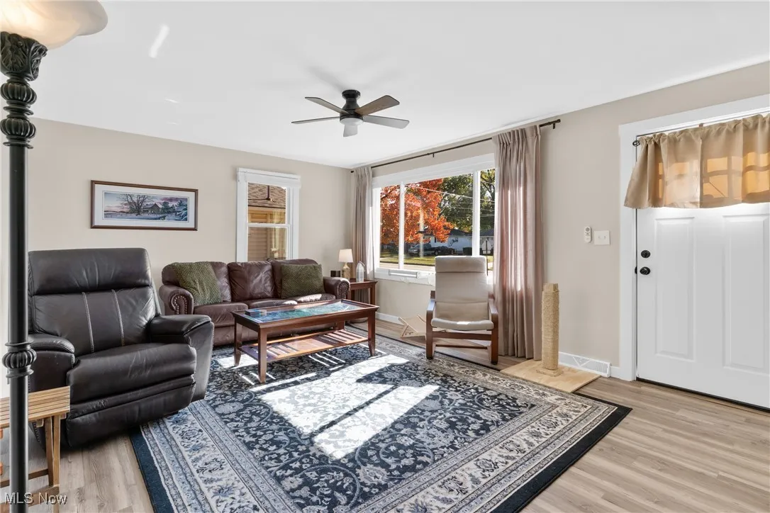 Living room with light wood-style floors and ceiling fan