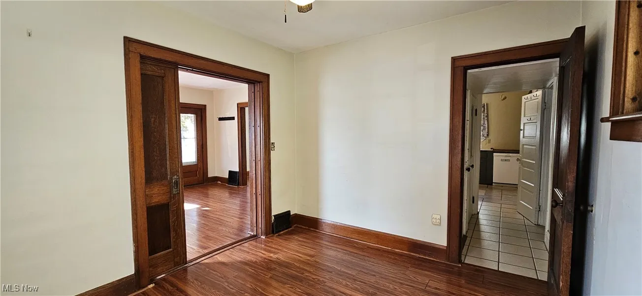 Bonus room with pocket door, wood trim and dark floors