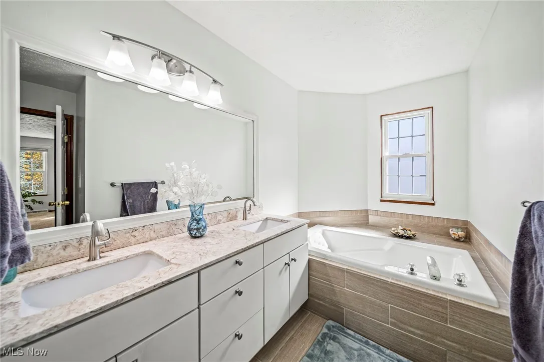 Primary bathroom with dual vanity, tile shower and tub.