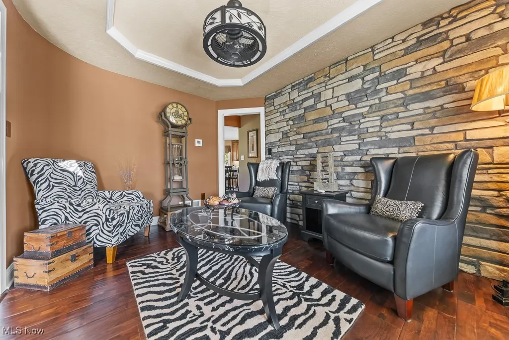 Sitting room featuring a raised ceiling and dark wood finished floors