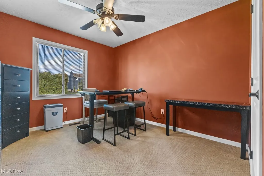 Bedroom with light colored carpet, a textured ceiling, and a ceiling fan