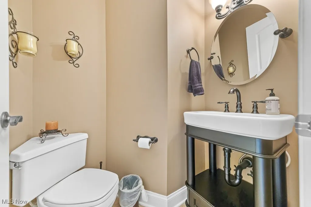 Half bathroom featuring toilet and baseboards