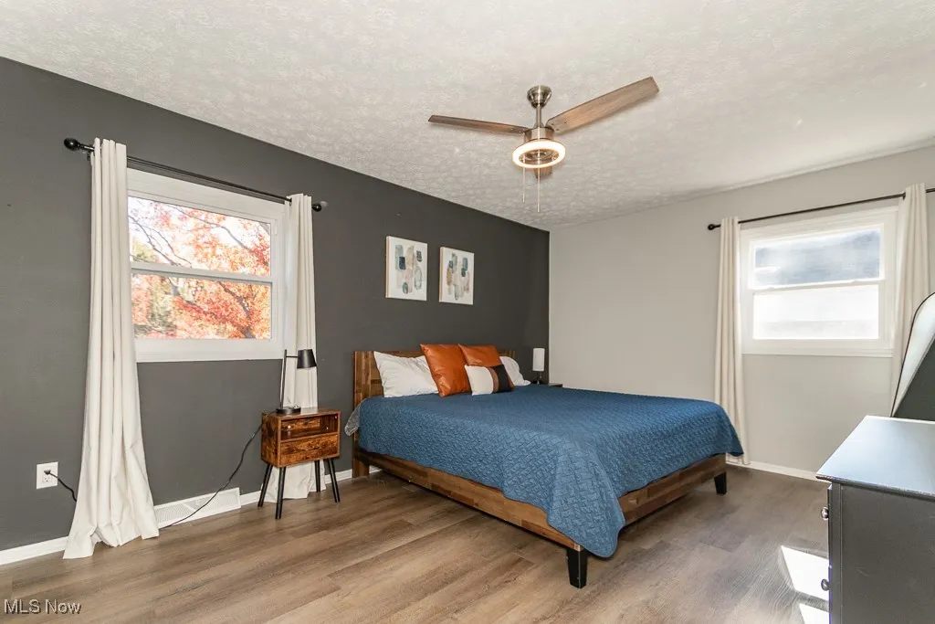 Bedroom featuring ceiling fan, a textured ceiling, and wood finished floors