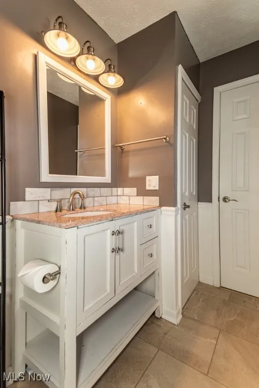 Bathroom featuring vanity, a textured ceiling, and light tile patterned floors