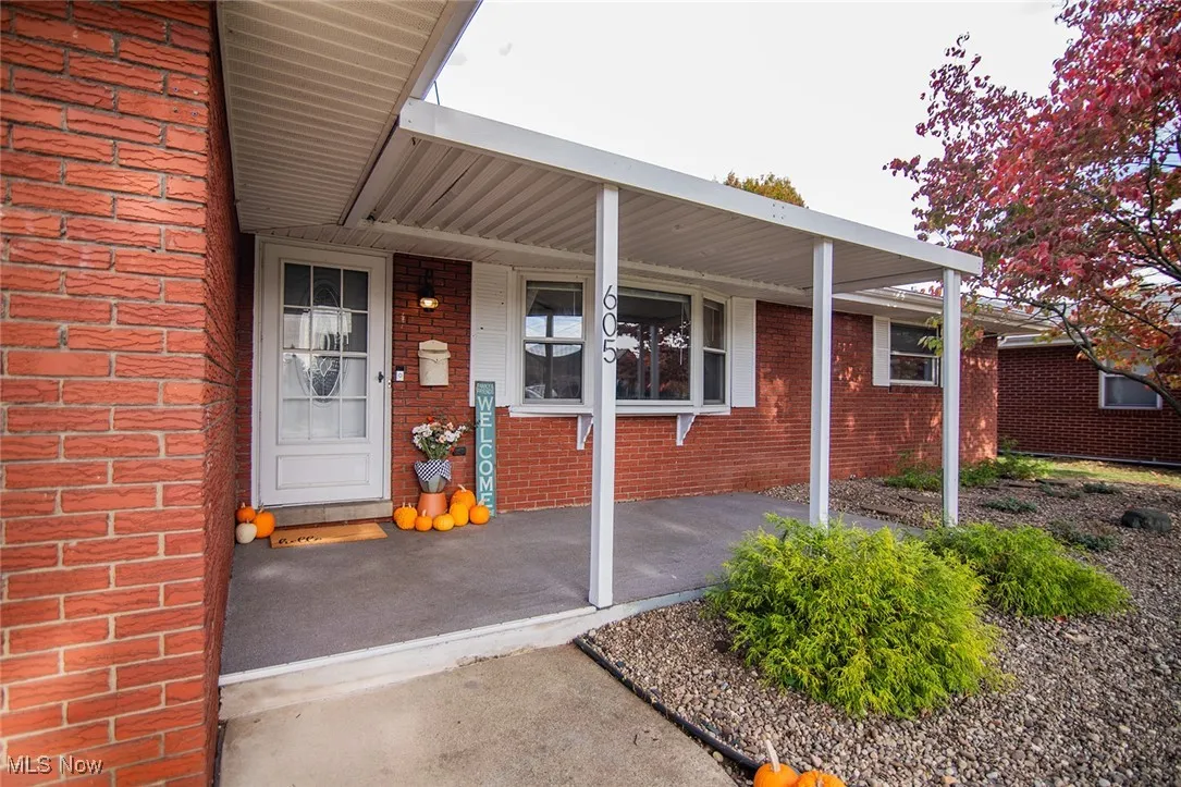 Entrance to property featuring a porch and brick siding