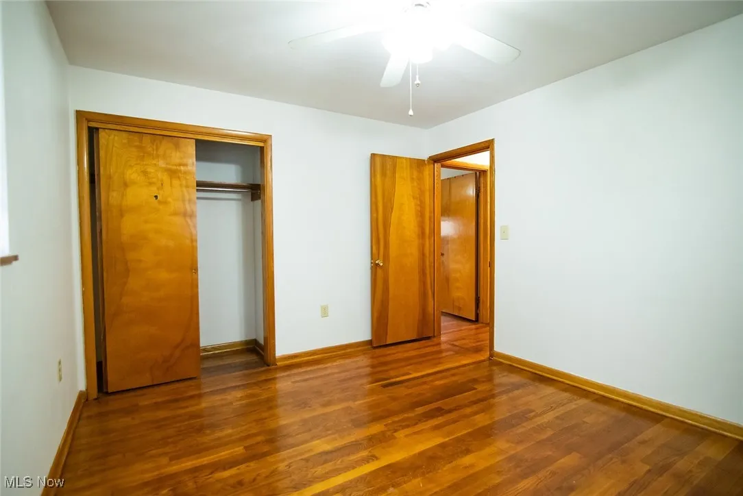 Unfurnished bedroom featuring dark wood finished floors, ceiling fan, and a closet