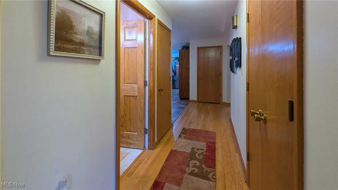 Stained hardwood wide hallway and doors