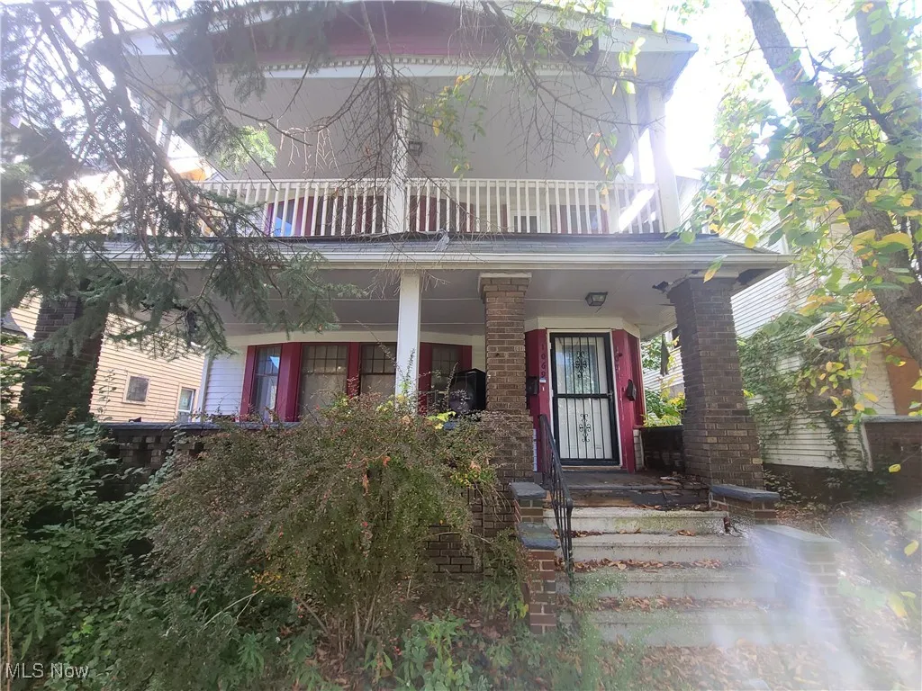 View of front of home with a porch and a balcony