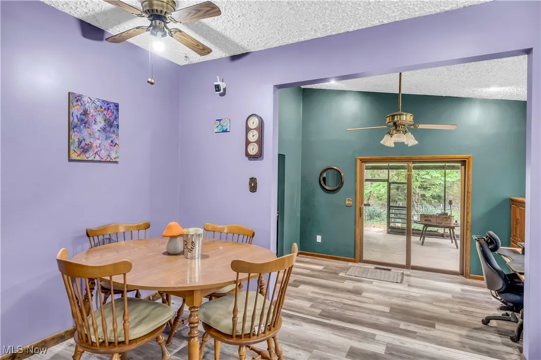 Dining area featuring ceiling fan, a textured ceiling, and wood finished floors