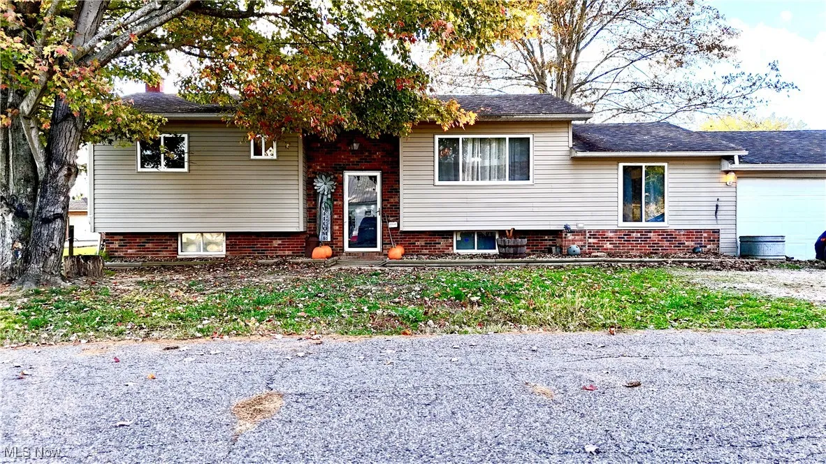 View of front of home featuring brick siding and a garage