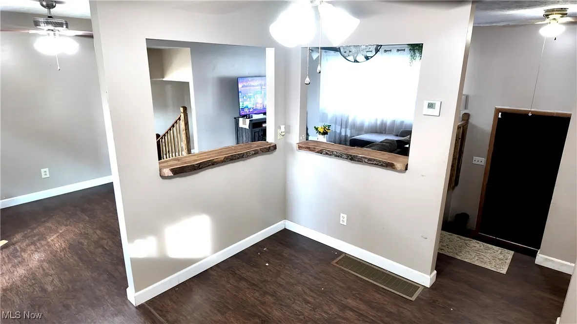 Corridor with dark wood-style flooring and an upstairs landing