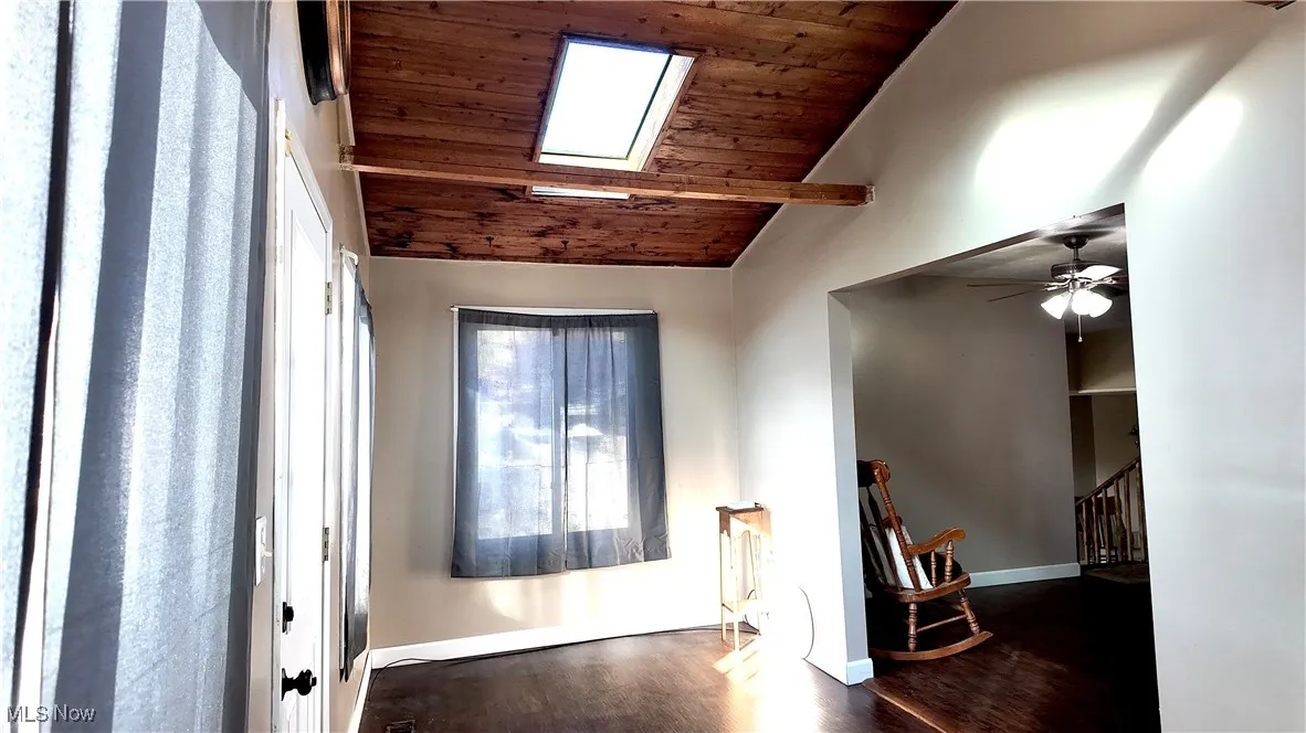 Foyer featuring wood ceiling, dark wood-style floors, and a skylight