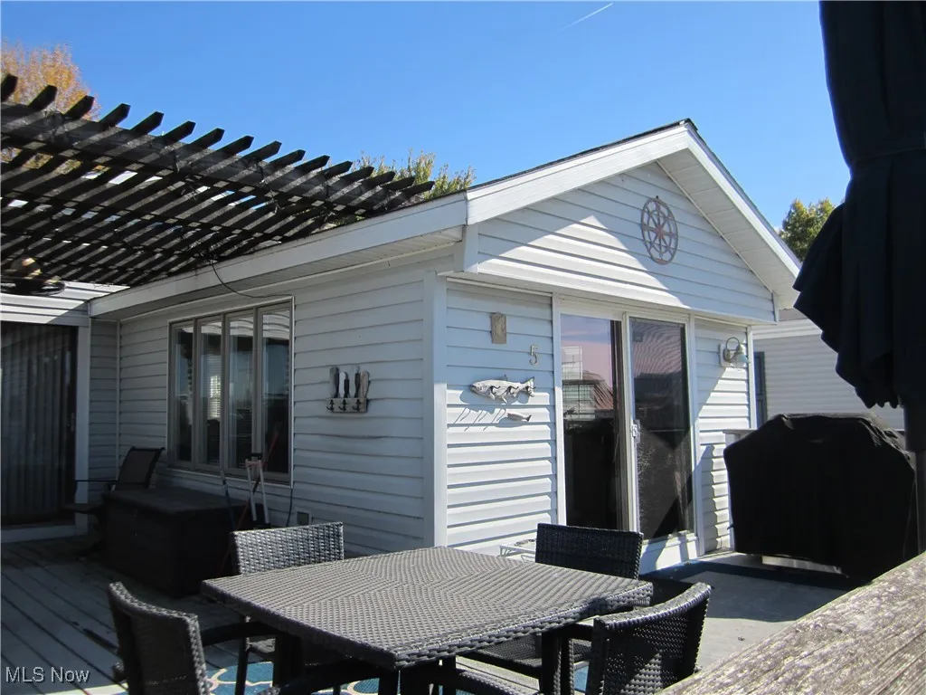 Wooden terrace featuring outdoor dining space, area for grilling, and a pergola