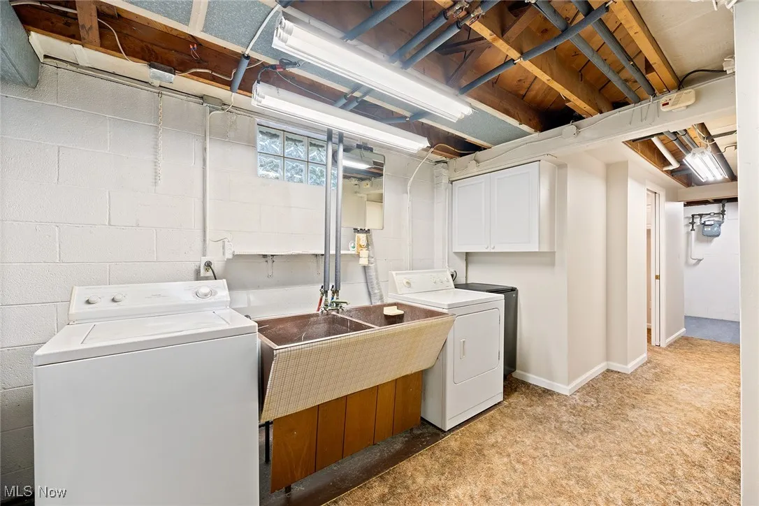 Laundry room featuring independent washer and dryer and cabinet space