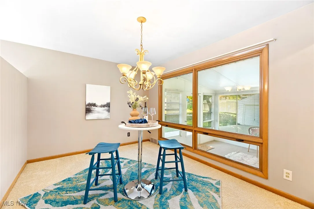 Dining room featuring light colored carpet and a chandelier