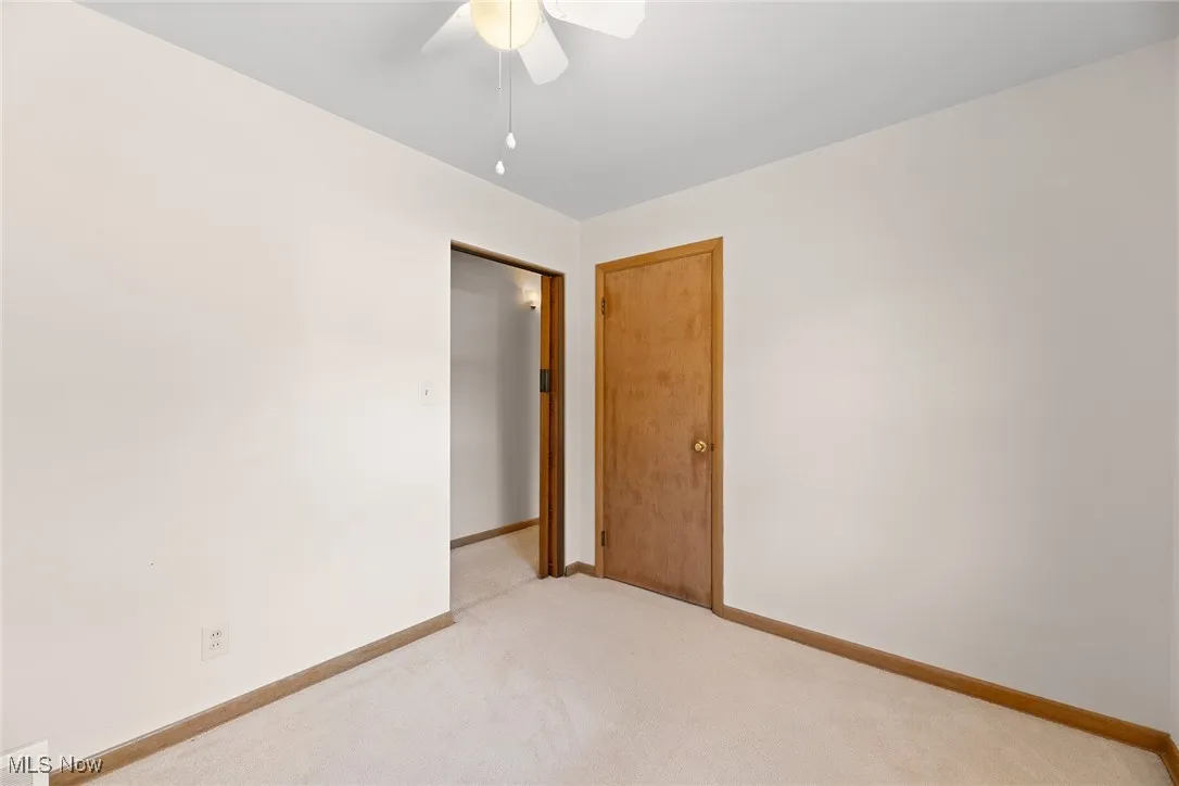 Unfurnished bedroom featuring carpet flooring and ceiling fan