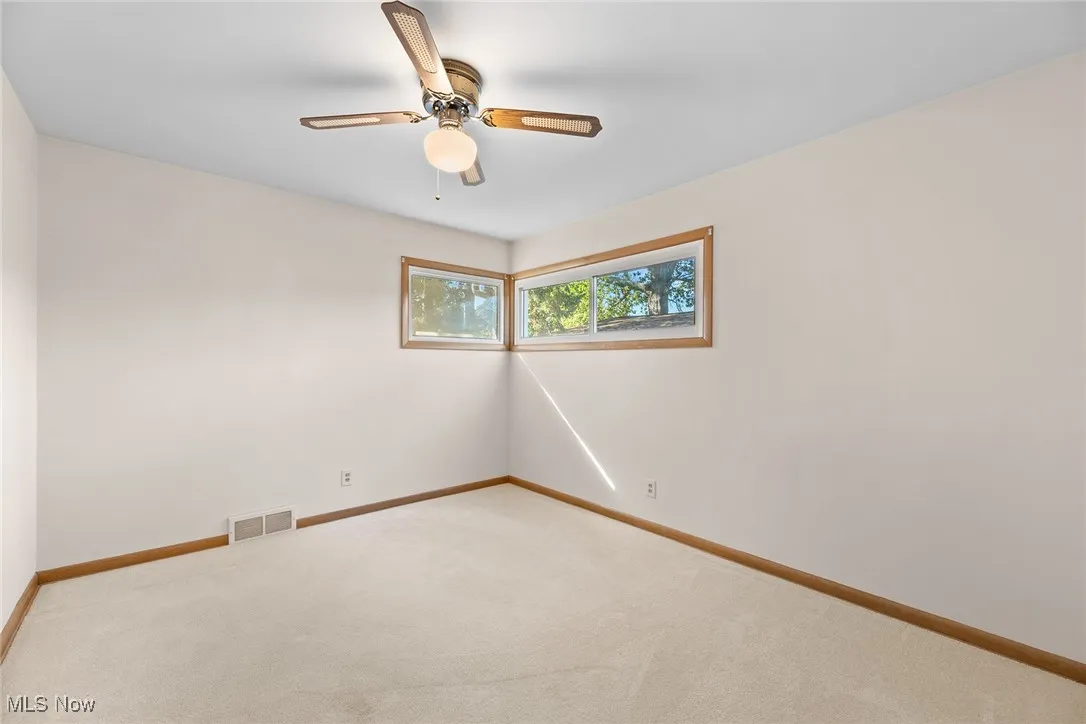 Spare room featuring carpet and a ceiling fan