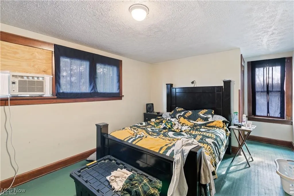 Bedroom with a textured ceiling and cooling unit