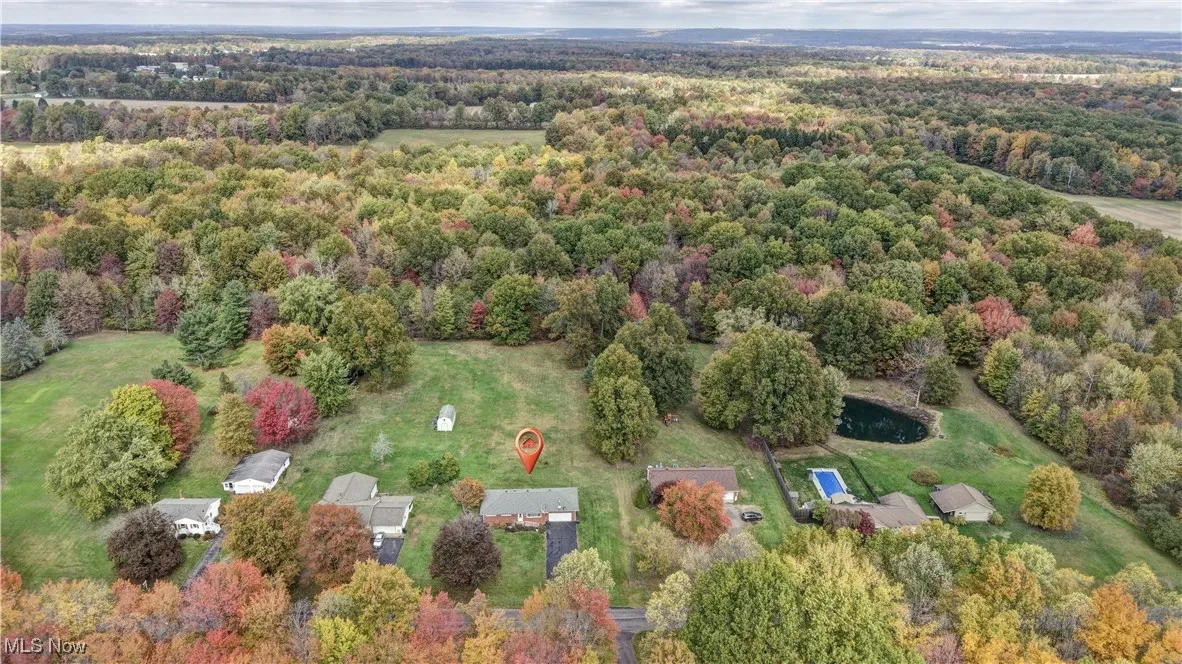 View of property location with a heavily wooded area