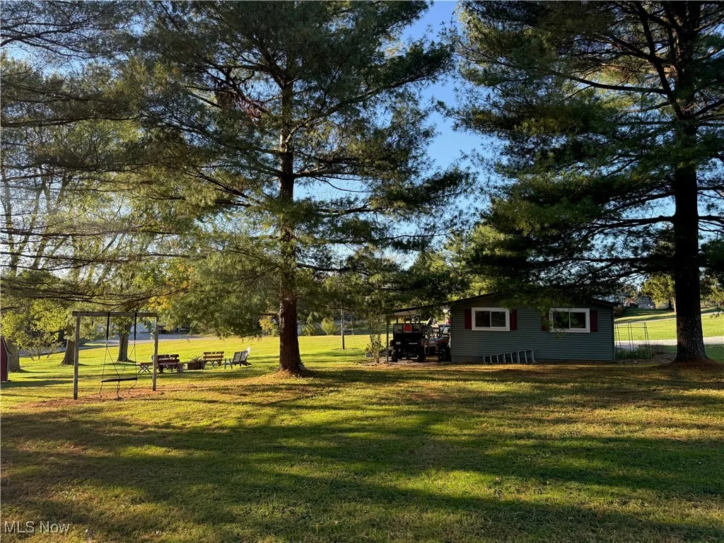 View of grassy yard featuring view of scattered trees