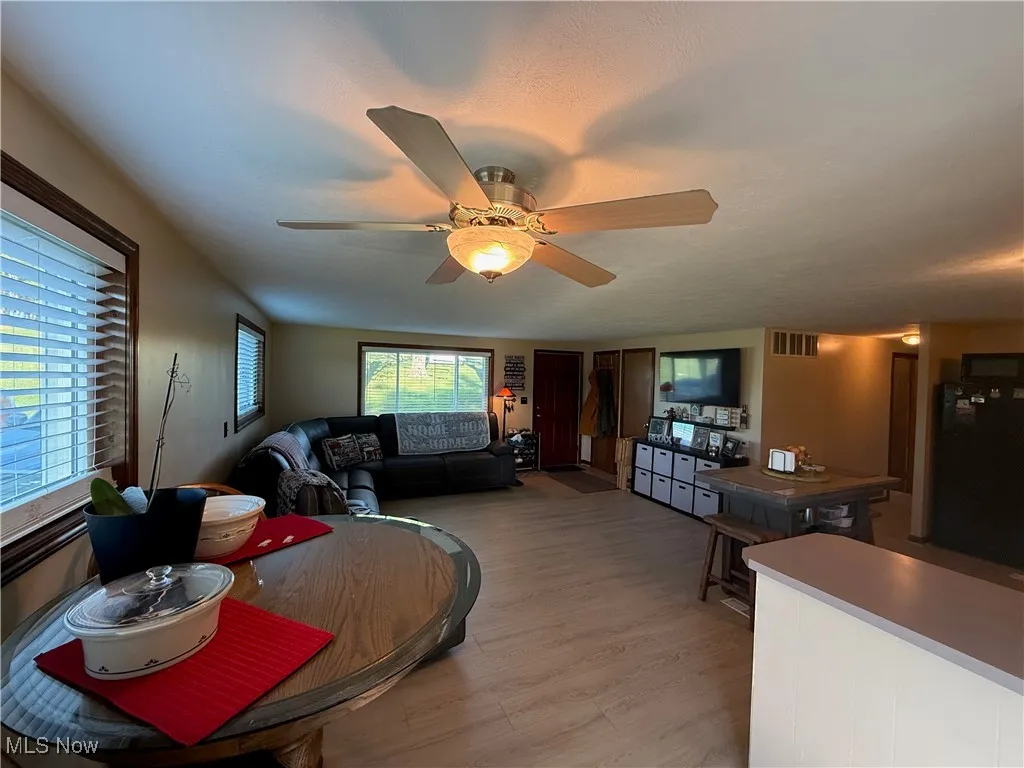 Dining room with light wood-style floors and ceiling fan