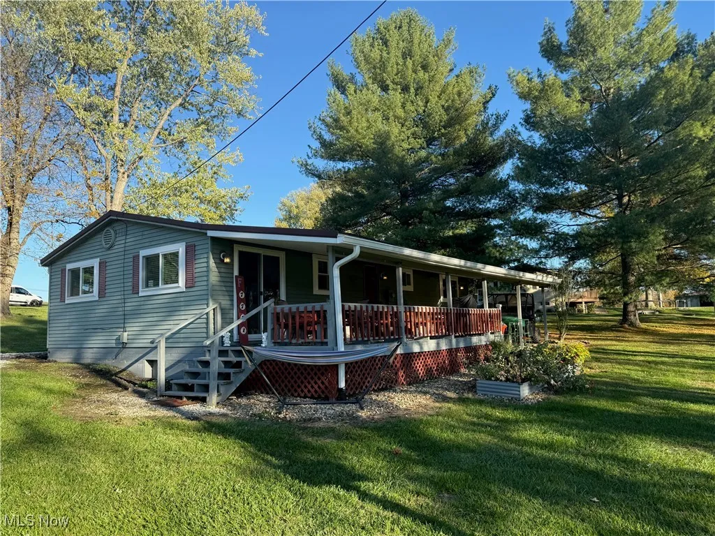 View of front of property with covered porch and a front yard