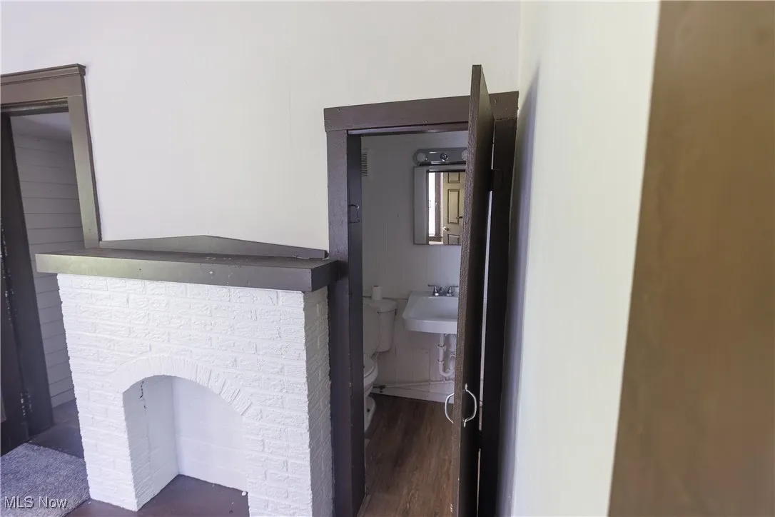 Half bath featuring dark wood finished floors and toilet