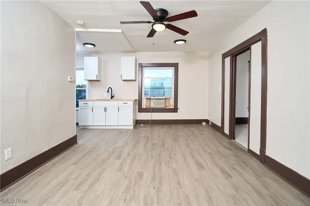 Unfurnished living room with light wood-style flooring, healthy amount of natural light, and ceiling fan