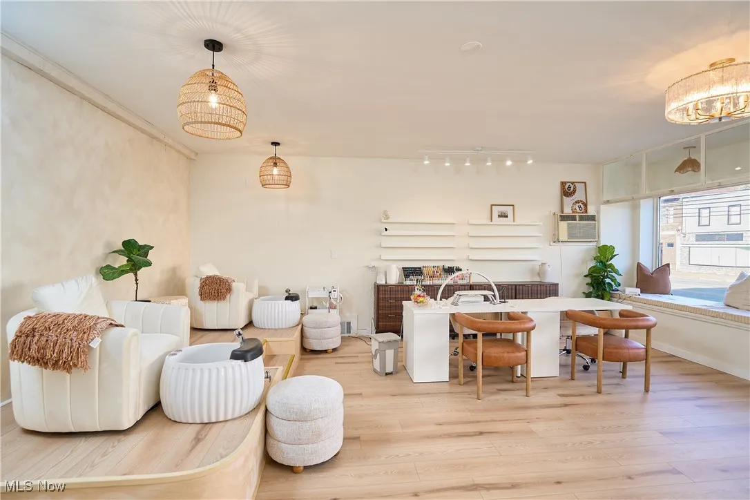 Living area with wood finished floors and an AC wall unit