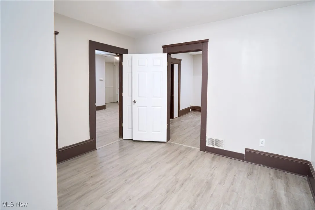 Unfurnished room featuring light wood finished floors and baseboards