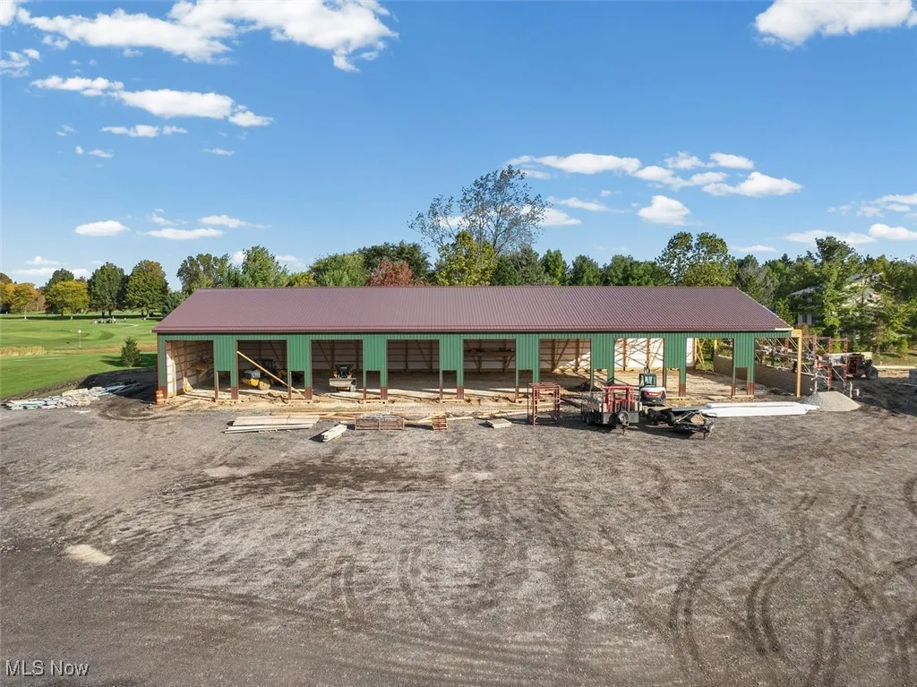 View of front of house featuring an outbuilding, a patio area, and a metal roof