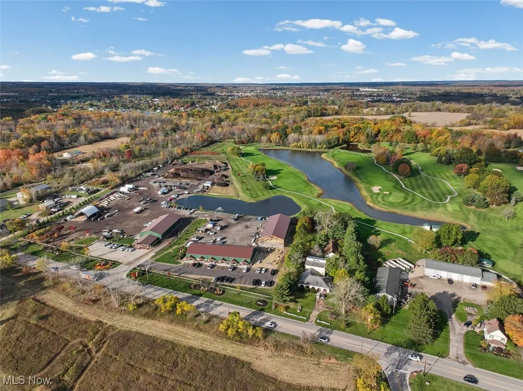 Aerial view of property and surrounding area featuring a large body of water and a local golf course