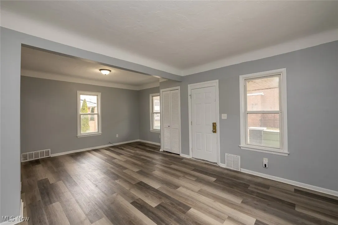 Foyer entrance featuring dark wood-style floors and beam ceiling