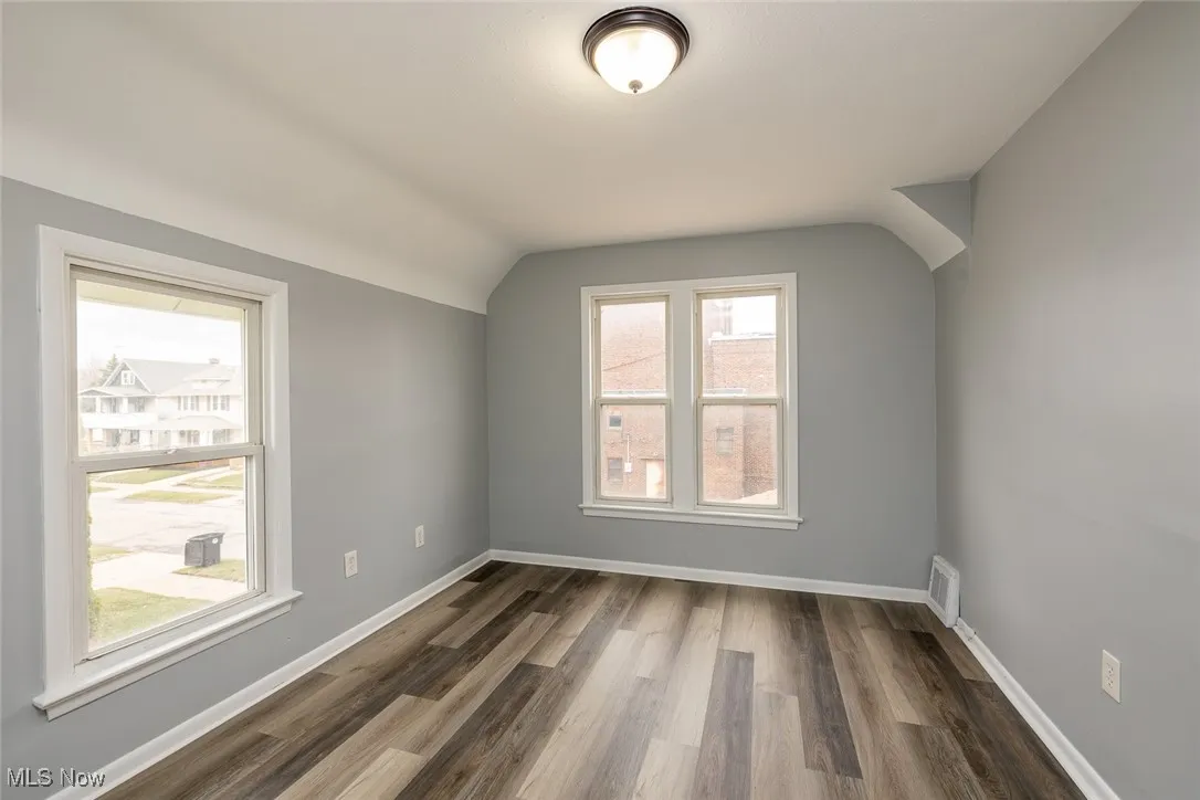 Additional living space featuring wood finished floors and lofted ceiling