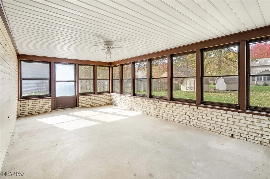 Unfurnished sunroom with ceiling fan