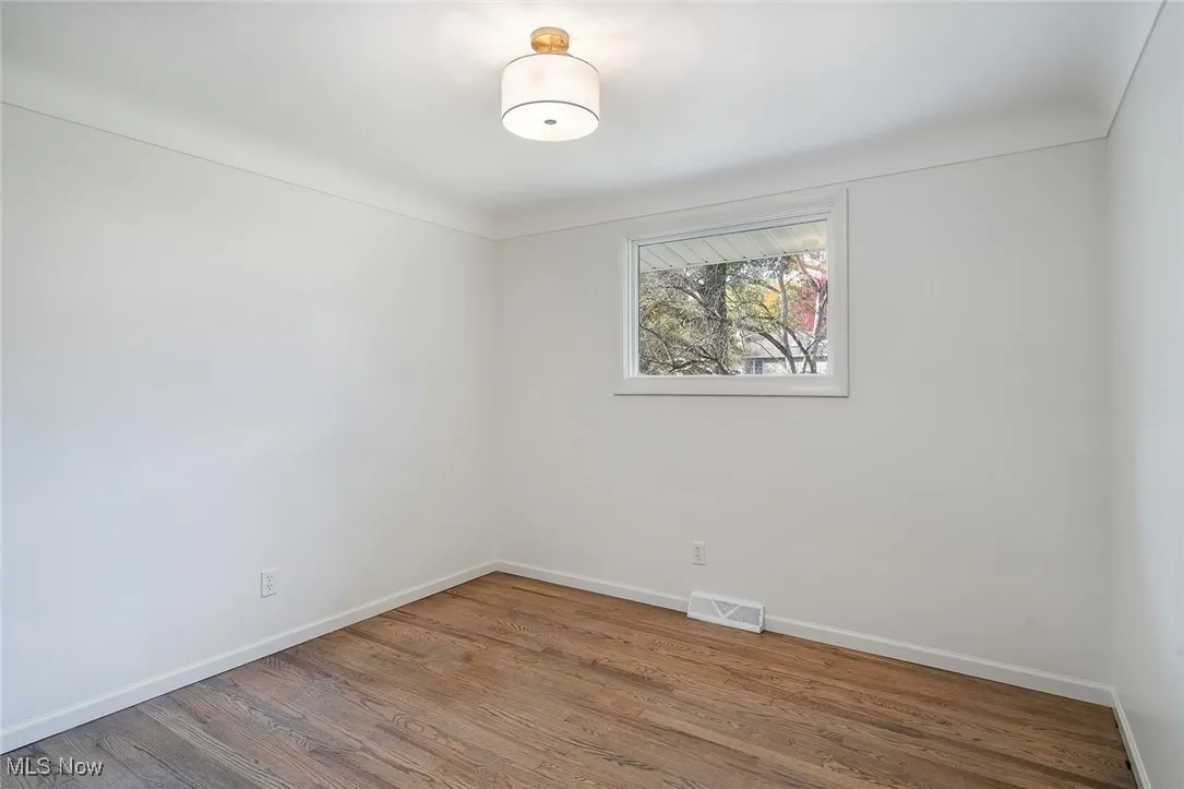 Empty room featuring wood finished floors and baseboards
