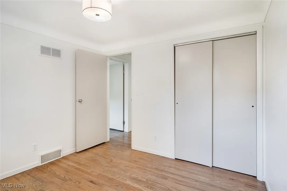 Unfurnished bedroom featuring light wood-style flooring and a closet