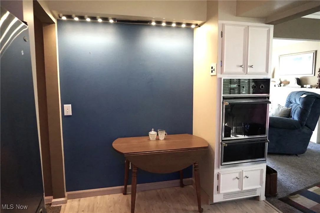Eating area of eat-in kitchen features track lighting