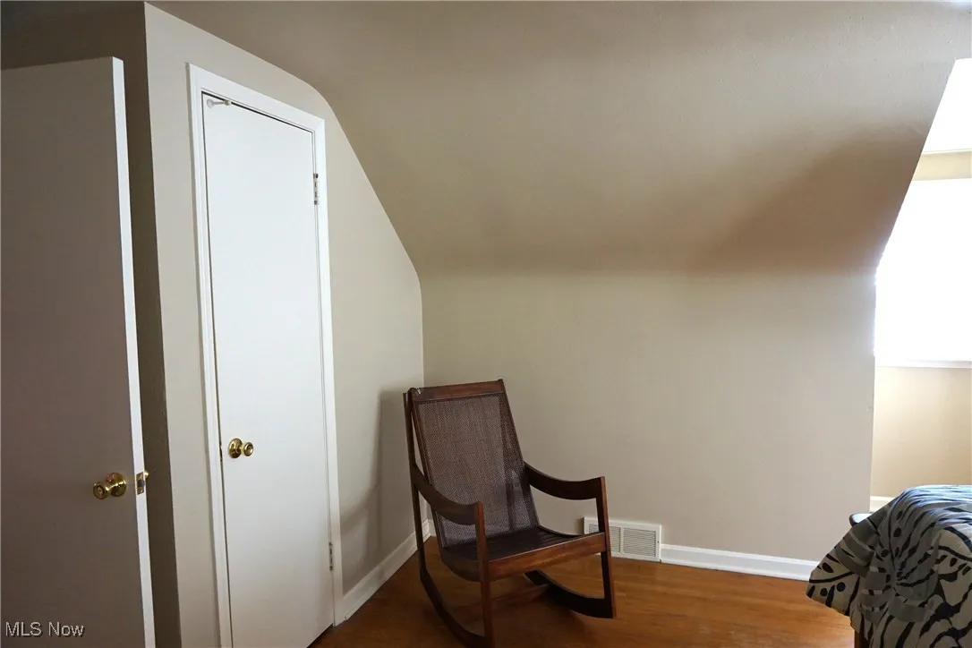 Bedroom 1 view 3 with dark wood-style floors and lofted ceiling